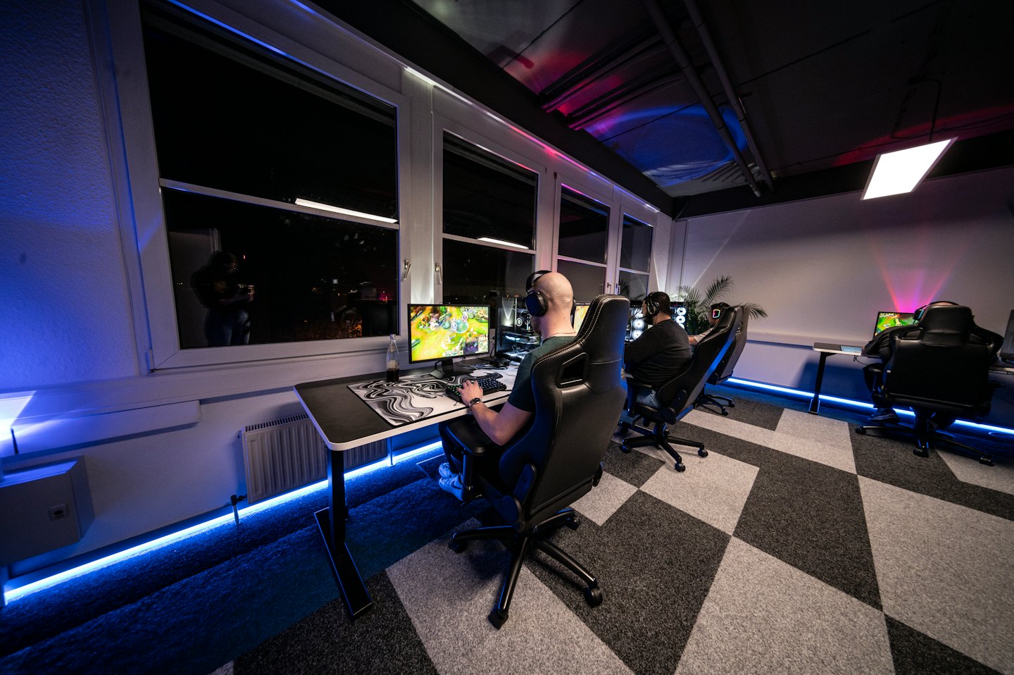 Spieler konzentriert sich auf Videospiele in einem modernen Gaming-Raum.